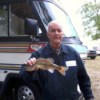 photo of man holding a fish he caught