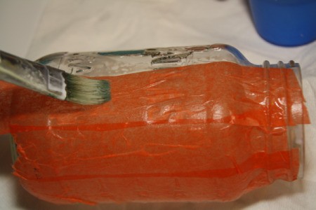 Putting Orange Tissue Paper on Mason Jar