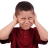 A child not listening by covering his ears.