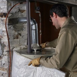 Photo of someone installing a water heater blanket.