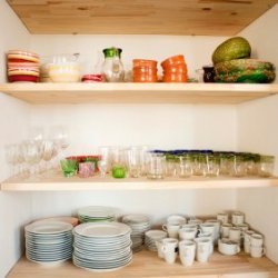 Dishes arranged inside cabinet.