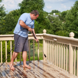 Man Pressure washing his Wood Deck