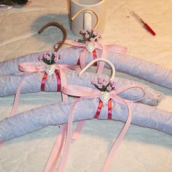 Finished padded hangers wrapped in light blue lace woth satin ribbons around the neck.