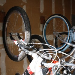 Two bikes hanging from J hooks.
