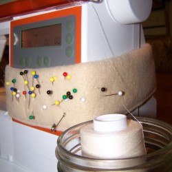 Spool of serger thread in container next to machine.
