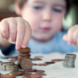 A young child counting coins.