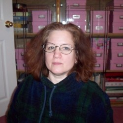 Woman sitting in front of pink, labelled photo boxes