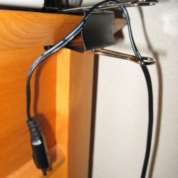 Black Paper Clip attached to edge of desk for cord