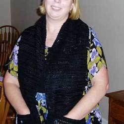 A black crocheted scarf with pockets.