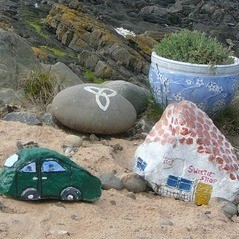 A collection of rocks painted to look like village buildings, overlooking the sea.