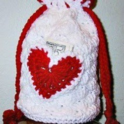 white crochet purse with red heart and pull strings