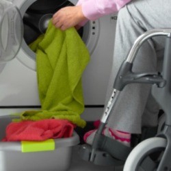 In a wheelchair doing laundry.