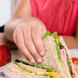 A girl eating packed lunch at school.