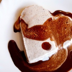 Strawberry ice cream cut in the shape of a heart.