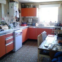 Kitchen with orange cupboards.