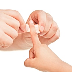 Putting bandaid on child.