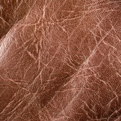 Close up of an old brown leather couch.