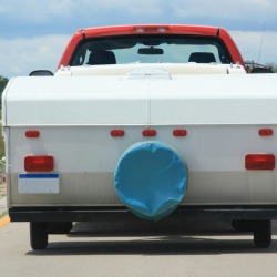A truck towing a vintage popup camper.