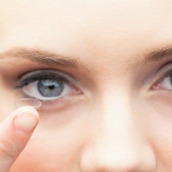 A woman putting on contact lenses.
