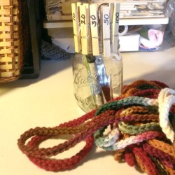 glass jar with clothes pins behind crochet chain