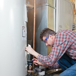 man maintaining a water heater 
