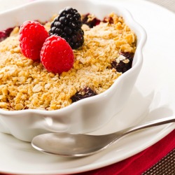 mixed berry cobbler in white scalloped dish