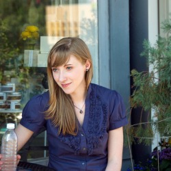 woman sitting outside small shop