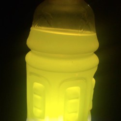 A sports drink with a light behind it, making a lantern.