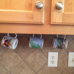mugs hanging under cabinets