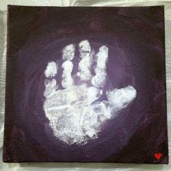 A child's white handprint on black paper.