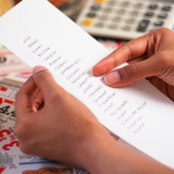 Hands holding shopping list.