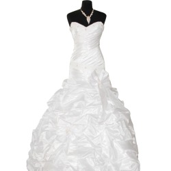 White wedding dress on black dress form against white background