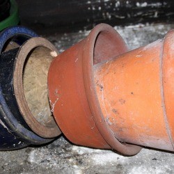 stack of dirty flower pots on their side