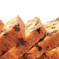 Loaf of date bread cut into slices against a white background