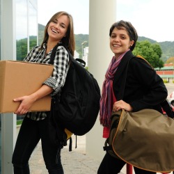 Two college students moving into their dorm.