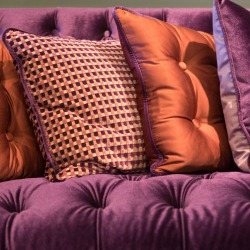 A vintage couch with many cushions.