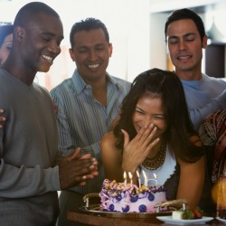 Surprised woman and a group of friends with a cake
