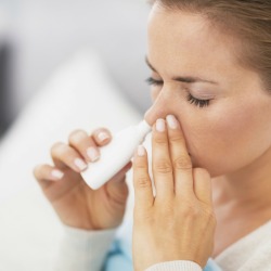 A woman using nasal drops.