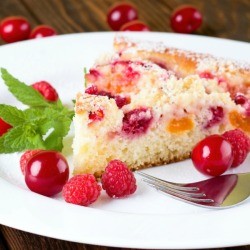 Dump cake (cake with canned mixed fruit in it) on a white plate.