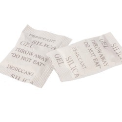 Two silica packets on a white surface.