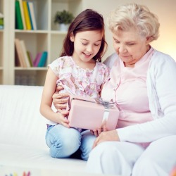 Grandmother and Granddaughter holding pink wrapped present