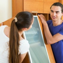 Couple moving heavy cabinet