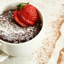 Chocolate mug cake garnished with a sliced strawberry