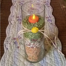 Candle vase filled with dried beans and peas.