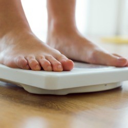 A woman standing on a scale.