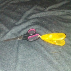 scissors with large bright yellow clip attached 