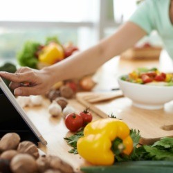 A woman checking the healthy recipe she is making.