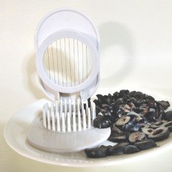 egg slicer on a plate with sliced olives
