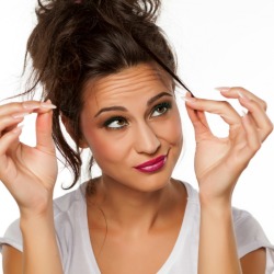 A woman looking at her hair with dismay.