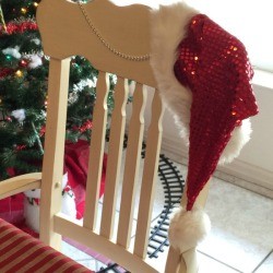 Santa hat on back of chair next to Christmas tree